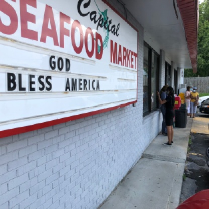 Customers wait to enter Capital Seafood Market in Durham. Photo by Matt Goad